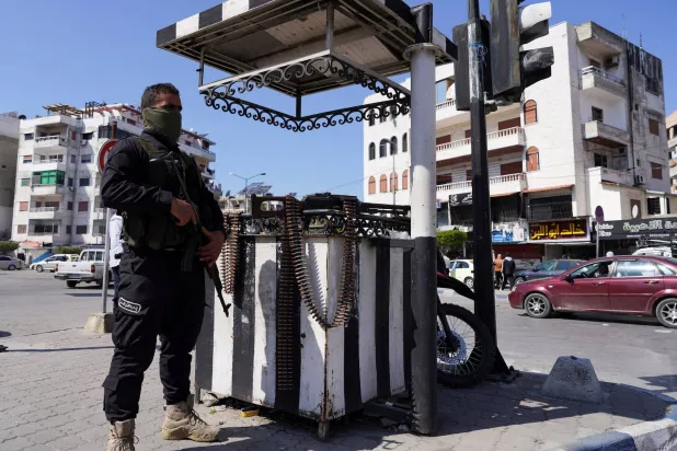 A member of the Syrian security forces stands guard along a street in Latakia, Syria March 10, 2025. (Reuters) 