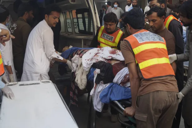 مصابون جراء الهجوم الذي استهدف نقطة تفتيش أمنية في ديرة إسماعيل خان لدى وصولهم إلى المستشفى (إ.ب.أ)