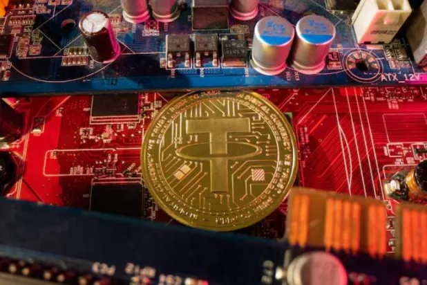 تمثيل للعملة الرقمية «تيثر» موضوع على لوحة أم لجهاز حاسوب (رويترز)