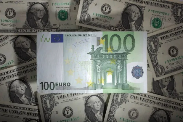 ورقة نقدية من فئة 100 يورو فوق أوراق نقدية من فئة دولار واحد في وارسو (رويترز)