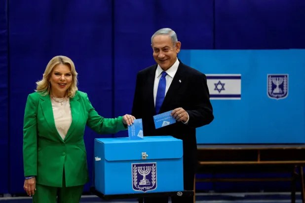 رئيس الوزراء الإسرائيلي السابق بنيامين نتنياهو يقف إلى جانب زوجته سارة في أثناء الإدلاء بصوتيهما في يوم الانتخابات العامة الإسرائيلية وذلك في مركز اقتراع بالقدس في الأول من نوفمبر 2022 (رويترز)