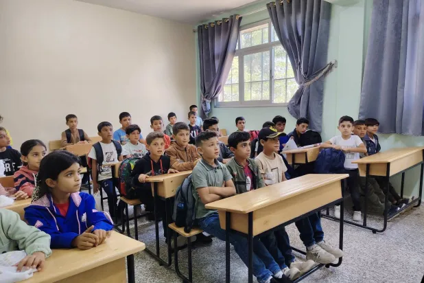 تلامذة صغار التحقوا بمدرسة في القصير بريف حمص جرى إعادة تأهيلها بتمويل من مركز الملك سلمان (مديرية التربية والتعليم بحمص)
