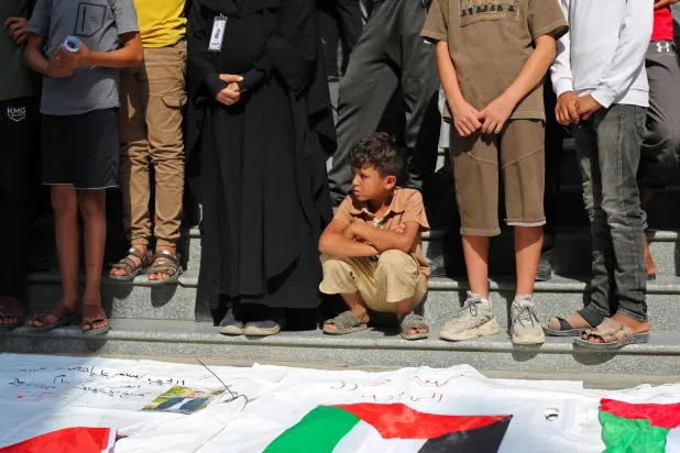 صبي فلسطيني يتبع المشيعين في جنازة جماعية في مخيم النصيرات للاجئين وسط قطاع غزة (أ.ف.ب)