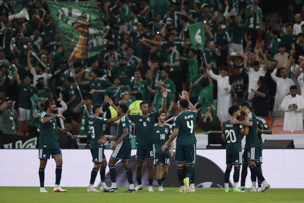 لاعبو السعودية يحتفلون بالتأهل (رويترز)