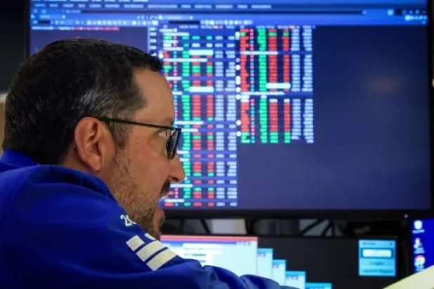 يعمل متداول في العقود الآجلة والخيارات في قاعة بورصة نيويورك «إن واي إس إي أميركان» (رويترز)