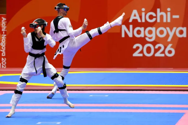 Kazakhstan's Rita Bakisheva (L) competes against Jordan's Mohammad Aladarbi in the mixed individual virtual taekwondo competition during the 2026 Asian Games at the Toyohashi Gymnasium in Toyohashi on October 2, 2026. (Photo by DAVID GRAY / AFP)