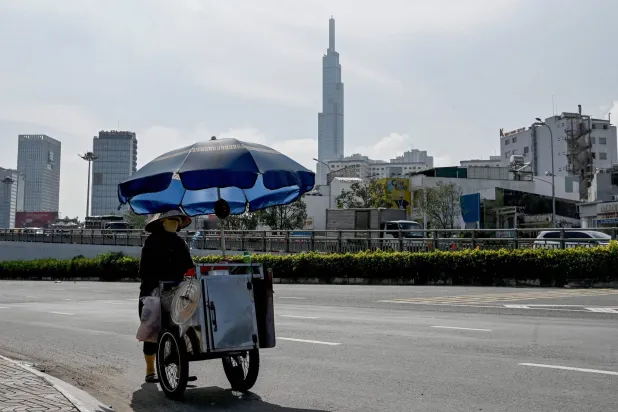 A street food vendor pushes a cart along the road in Ho Chi Minh City on October 2, 2026. (Photo by Nhac NGUYEN / AFP)