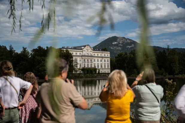 يلتقط زوارٌ صوراً لفندق «شلوس ليوبولدسكرون» (Schloss Leopoldskron) في سالزبورغ بالنمسا والذي استُخدم مقراً لإقامة عائلة «فون تراب» بفيلم «صوت الموسيقى» (The Sound of Music) (إسكندر خليف - نيويورك تايمز)