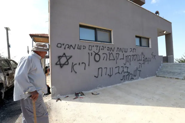 فلسطيني أمام منزل اعتدى عليه مستوطنون إسرائيليون قرب رام الله بالضفة الغربية 28 سبتمبر الماضي (إ.ب.أ)
