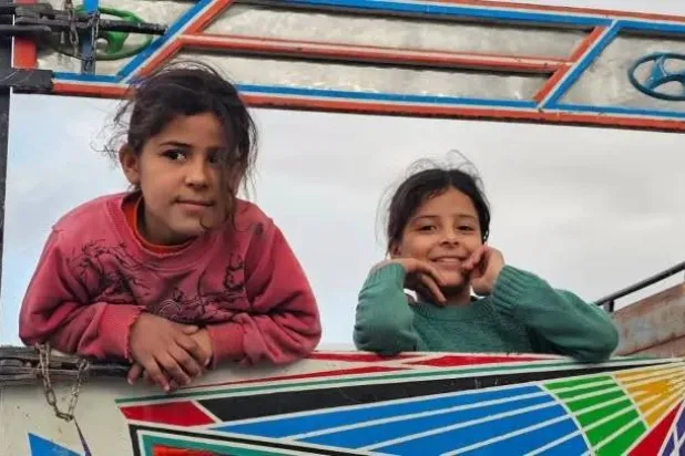 طفلتان تبدو عليهما بهجة العودة إلى بيتهما في رأس العين/ سري كانية (مركز رأس العين الإعلامي)