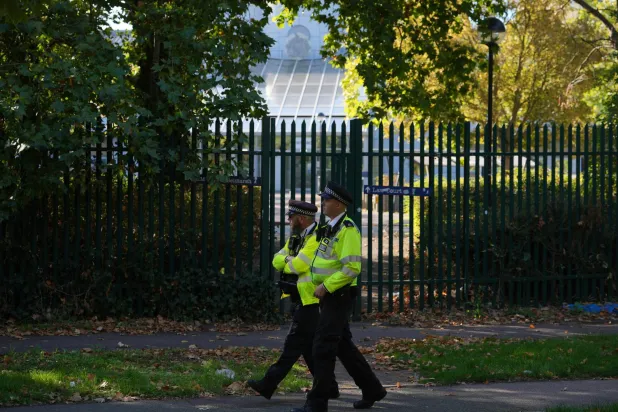 Police officers patrol outside Woolwich Crown Court as the trial of three Iranian nationals, charged with spying offenses on behalf of Iran's foreign intelligence service, takes place in London, Monday, Oct. 5, 2026. (AP Photo/Kin Cheung)