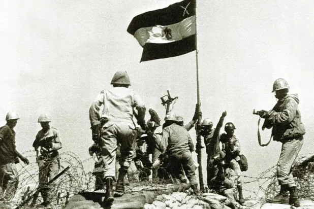 جنود مصريون يرفعون العلم على الضفة الشرقية من قناة السويس خلال معارك حرب أكتوبر 1973 (أ.ب)