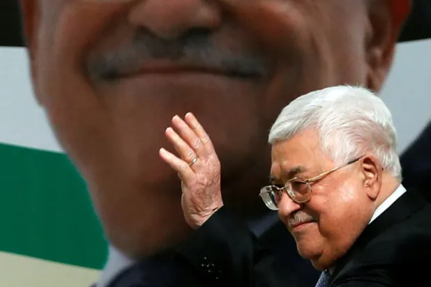 الرئيس الفلسطيني محمود عباس يلوح بيده خلال مراسم إحياء الذكرى الخامسة والخمسين لتأسيس حركة فتح في رام الله بالضفة الغربية عام 2019 (رويترز)