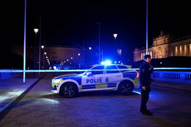 İsveç’in başkenti Stockholm’ün merkezinde dün polisin bir kişiye ateş açmasının ardından nöbet tutan polis. (Reuters)