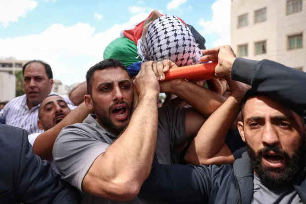 مشيعون يحملون جثمان الفلسطيني علي البزاري في مستشفى رفيديا بمدينة نابلس في الضفة الغربية (أ.ف.ب)