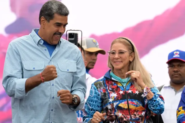 (foto altı) Venezuela Devlet Başkanı Nicolas Maduro, 2024 yılında Karakas’ta düzenlenen seçim kampanyasının kapanış mitinginde eşi Cilia Flores ile birlikte dans ediyor. (AFP)