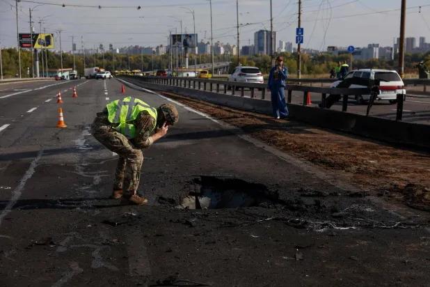 Police officers look at the damages following a Russian drone strike on the Northern Bridge in Kyiv on October 4, 2026, amid the Russian invasion of Ukraine. (Photo by Mykola TYMCHENKO / AFP)