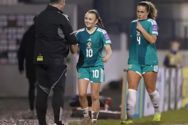 كيري هاليداي لاعبة منتخب آيرلندا الشمالية تتلقى تحية مدربها مايكل مكاردل خلال إحدى مباريات تصفيات كأس العالم للسيدات 2027 (أ.ب)