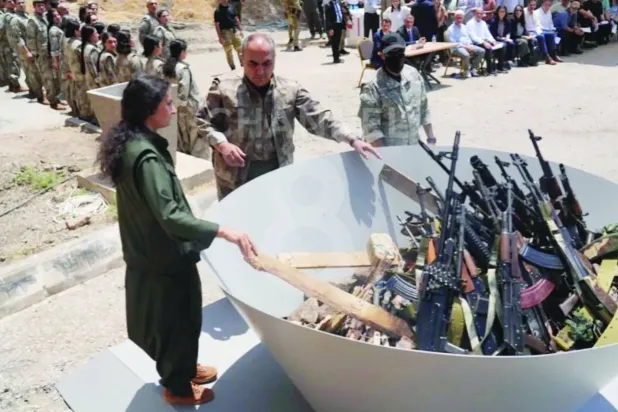Kürdistan Topluluklar Birliği (KCK) Eş Başkanı Veysi Hozat, 11 Temmuz 2025’te Irak’ın kuzeyinde düzenlenen sembolik silah yakma töreninde, PKK’lı 30 militanın önünde yer aldı. (Reuters)