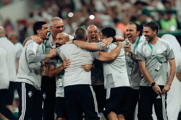 أعضاء الجهازين الفني والإداري للمنتخب يحتفلون باللقب (المنتخب السعودي)