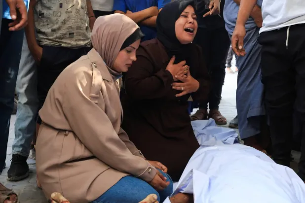 Gazze kentinde, sağlık görevlilerinin açıklamasına göre İsrail’in hava saldırısında hayatını kaybeden Filistinliler için düzenlenen anma törenine katılanlar (Reuters)