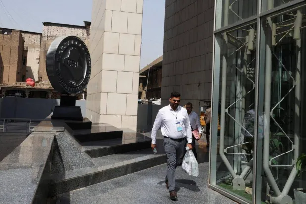 Employees walk outside the Central Bank of Iraq headquarters in Baghdad (Reuters)