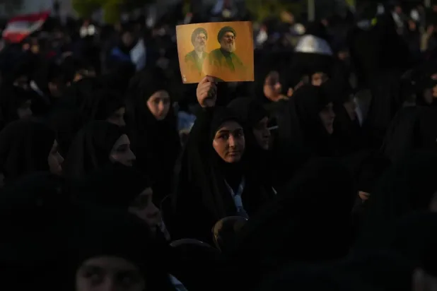 Hezbollah supporters hold up a portrait of the group’s former secretaries-general, Hassan Nasrallah and Hashem Safieddine, during the second anniversary of their assassinations in Beirut’s southern suburbs (AP). 