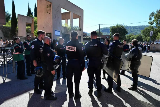 Policemen stand in front of Joseph-Lakanal high school after a headmaster was injured by a hunting rifle shot and a teenager was arrested in Aubagne, southern France, on October 12, 2026. (Photo by Miguel MEDINA / AFP)
