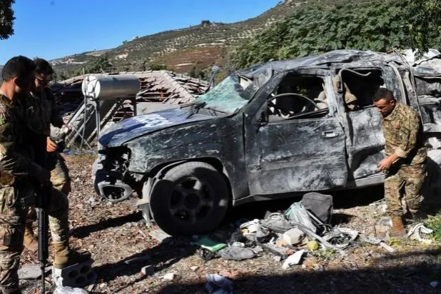 Lebanese army soldiers inspect a damaged vehicle marked with 'Press' at the site of an Israeli strike that killed a few journalists and wounded several others as they slept in guesthouses used by media, Lebanon's health ministry and local media reported, in Hasbaya in southern Lebanon, October 25, 2024. REUTERS/Stringer 