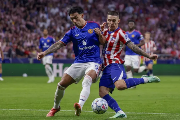 Manchester United's Argentine defender Lisandro Martinez (L) challenges for the ball against Atletico Madrid's Spanish defender Alejandro Grimaldo during the UEFA Champions League soccer match between Atletico Madrid and Manchester United, in Madrid, Spain, 13 October 2026. (EPA)