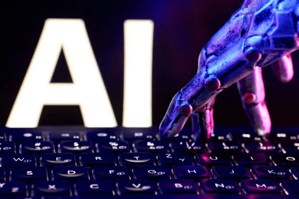 Letters spelling "AI," a keyboard and a robotic hand in this illustration created on September 23, 2026. (Reuters)