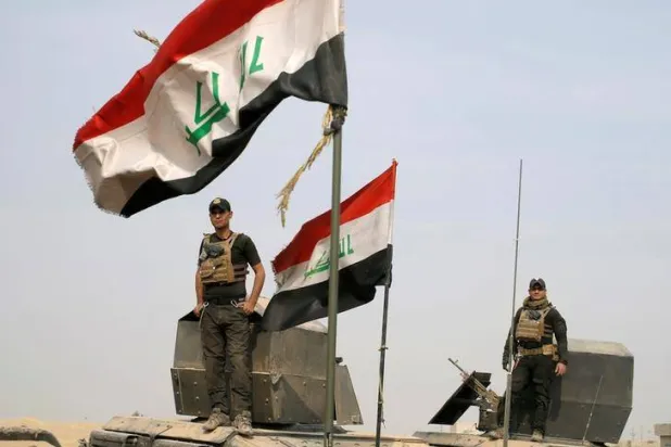 جنود من القوات الخاصة العراقية يقفون فوق مركبات مدرعة في قرية قرب الموصل بالعراق يوم 25 أكتوبر 2016 (رويترز)