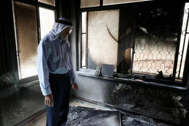 فلسطيني يتفقد الأضرار في مسجد أحرقه مستوطنون إسرائيليون في قرية مخماس قرب رام الله بالضفة الغربية الأربعاء (رويترز)