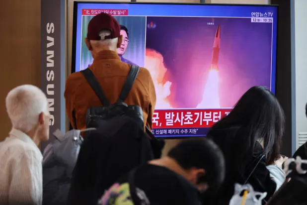 People watch a TV broadcasting a news report on North Korea firing multiple ballistic missiles toward the sea off its east coast, at a railway station in Seoul, South Korea, October 12, 2026. (Reuters) 