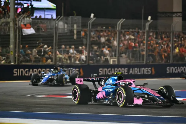 Alpine's Argentine driver Franco Colapinto (R) drives in front of Williams' Thai driver Alexander Albon during the Formula One Singapore Grand Prix at the Marina Bay Street Circuit in Singapore on October 11, 2026. (Photo by Lillian SUWANRUMPHA / AFP)