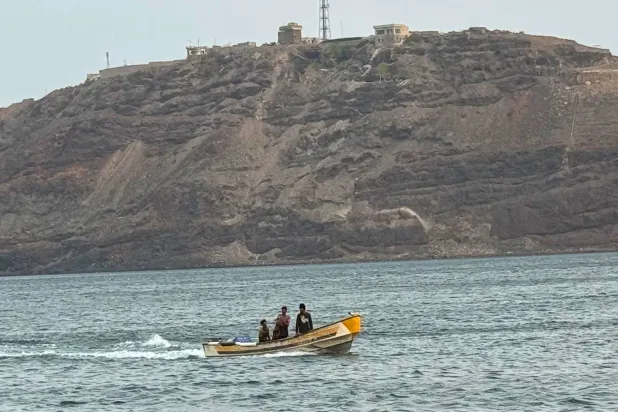 A boat motors under Al-Maashiq Presidential Palace, at top, in Aden, Yemen, Aug. 20, 2024. (AP)