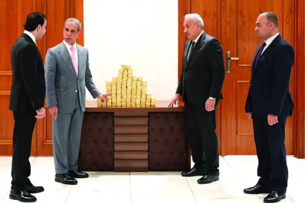 A photo released by Iraq’s judiciary shows Judge Faiq Zidan (second from left) inspecting gold bars seized in connection with the case of detained suspect Adnan al-Jumaili. 