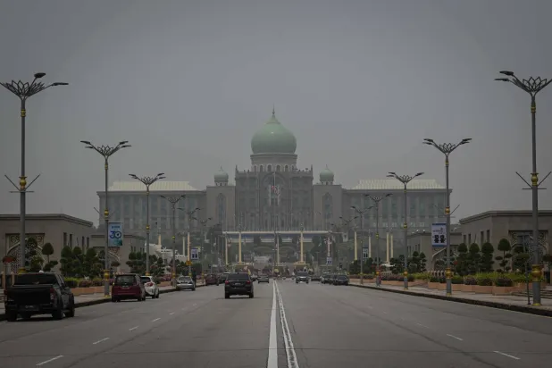 Motorists drive past the Prime Ministers’ Office in Putrajaya on October 17, 2026, as the country continues to be shrouded in haze caused by fires in Indonesia.  (Photo by Jam STA ROSA / AFP)