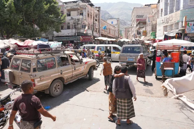 حشود من الناس في محطة للحافلات الصغيرة يستخدمها النازحون لمغادرة مدينة تعز (أ.ب)