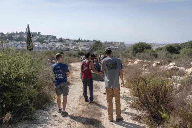 Israeli settlers (foreground) harvesting olives confront a Palestinian family outside the settlement of Alei Zahav, near the Palestinian town of Kafr al-Dik in the Israeli-occupied West Bank, on October 13, 2026. (AFP)