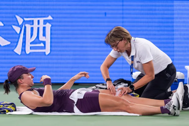 Iga Swiatek of Poland receives a medical timeout in a women's singles semifinal match against her compatriot Maja Chwalinska during the 2026 Wuhan Open tennis tournament in Wuhan in central China's Hubei Province on Saturday, Oct. 17, 2026. (Chinatopix Via AP)