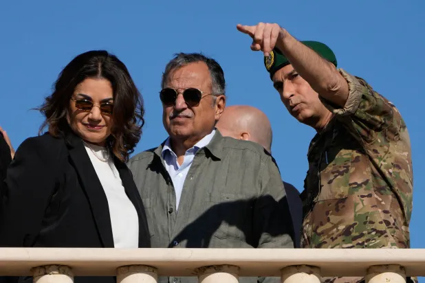 الأمين العام لجامعة الدول العربية نبيل فهمي مستمعاً إلى ضابط بالجيش اللبناني يشير إلى مناطق تحتلها القوات الإسرائيلية في زوطر الغربية بجنوب لبنان وإلى جانبهما وزيرة الشؤون الاجتماعية حنين السيد (أ.ب)