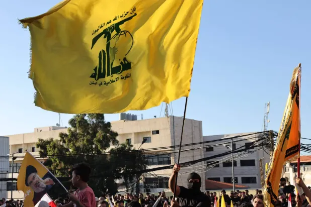 Hizbullah destekçileri, 27 Eylül’de Beyrut’un güney banliyölerinde düzenlenen etkinlikte örgütün bayraklarını sallarken (AFP)