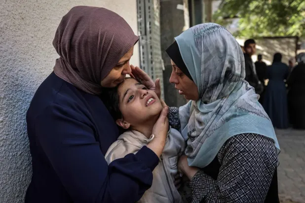 Gazze kentinin batısında İsrail hava saldırısının hedef aldığı bir dairede hayatını kaybeden Hamas’ın güvenlik teşkilatı yetkilisi Ekrem Yasin ve eşinin yakınları. (EPA)