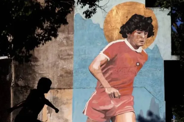 Arjantinli futbol efsanesi Diego Maradona’yı tasvir eden bir duvar resmi (Reuters)