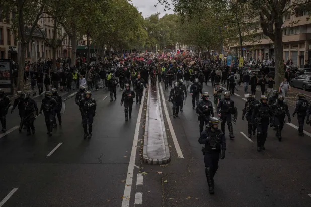 Protesters march behind French Republican Security Corps (CRS - Compagnies Republicaines de Securite) police officers during a demonstration to protest against the "high cost of living", in Toulouse, southwestern France, on October 17, 2026. (AFP)