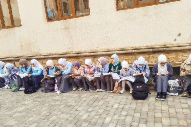 Sosyal medyada dolaşan bir fotoğrafta, Azerbaycanlı kız öğrencilerin başörtüleri nedeniyle sınıflara girmelerinin engellendiği görülüyor.