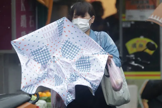 A woman struggles with winds generated by Typhoon Champi in Taipei, Taiwan, Friday, Oct. 23, 2026. (AP)