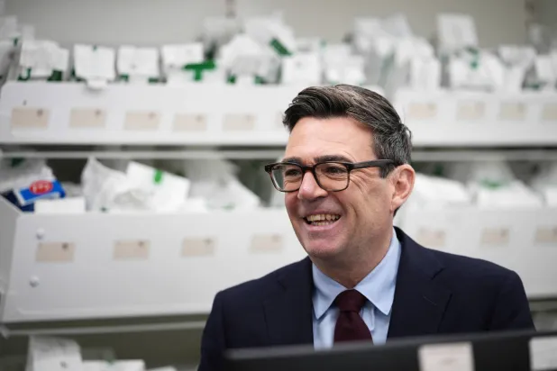  Britain's Prime Minister Andy Burnham meets pharmacy staff before receiving an annual seasonal flu vaccination at Kapoor Pharmacy Services in Chorlton-cum-Hardy in Manchester on October 22, 2026. (AFP) 
