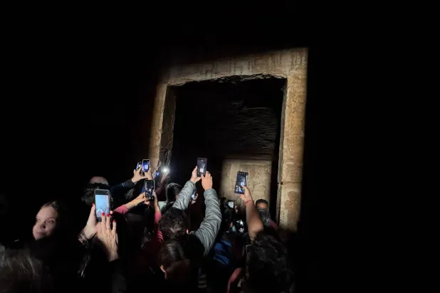  Tourists crowd to film the sun as it sends a beam of light into the Great Temple of Ramses II's dark inner chamber in Abu Simbel, 870 kilometers (540 miles) south of Cairo, Egypt, Thursday, Oct. 22, 2026, a rare 3,200-year-old astronomical ceremony that happens twice a year. (AP) 